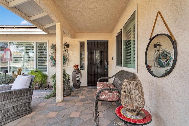 doorway to property with an outdoor living space, stucco siding, and a patio