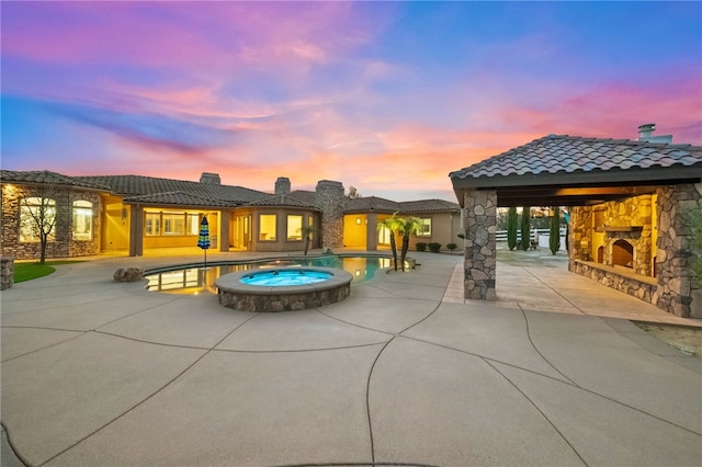 43840 E Vallejo Ave, Temecula, CA 92592 - back of house at dusk with a patio area, stone siding, an outdoor stone fireplace, a gazebo, and a tiled roof
