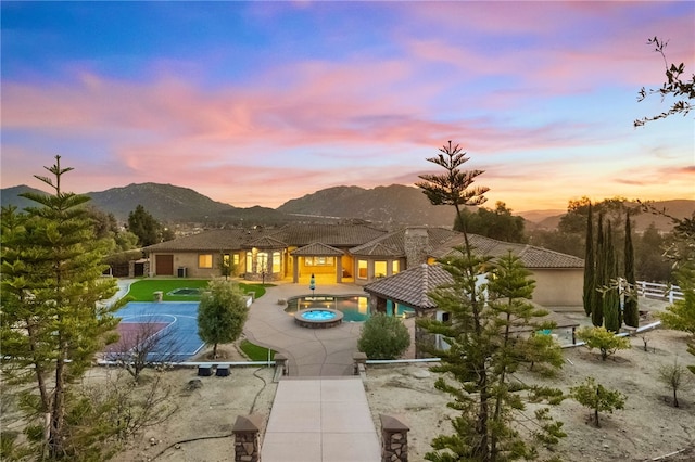 43840 E Vallejo Ave, Temecula, CA 92592 - back of house at dusk featuring a mountain view, a tile roof, a patio area, and stucco siding