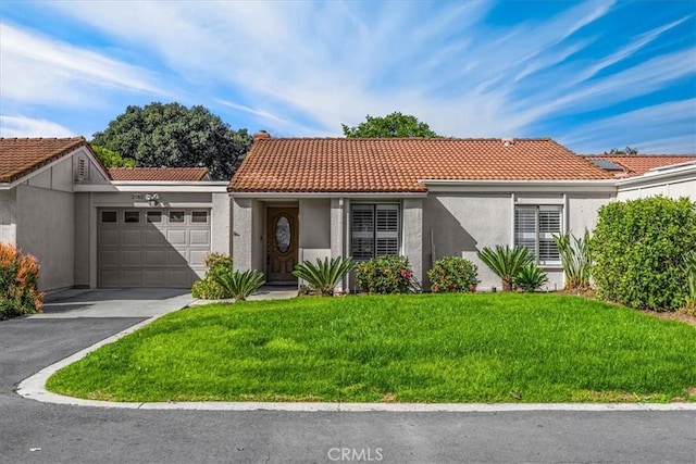 view of front of house with an attached garage, stucco siding, a tile roof, a front lawn, and aphalt driveway