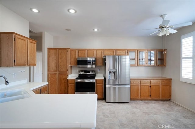 773 Camino De Plata, San Jacinto, CA 92583 - kitchen with a sink, light countertops, stainless steel appliances, and brown cabinetry