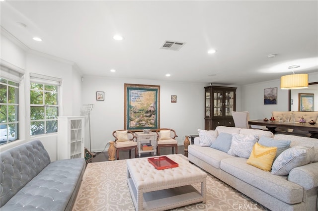 living room featuring baseboards, visible vents, crown molding, and recessed lighting