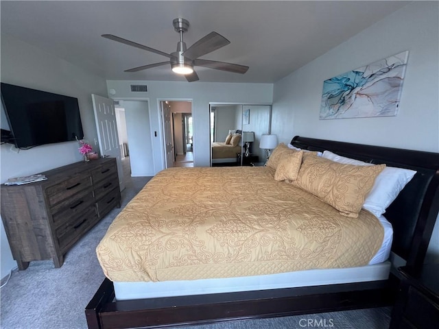 carpeted bedroom featuring a ceiling fan, a closet, and visible vents