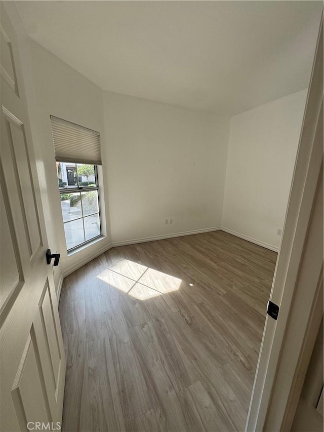 empty room featuring wood finished floors and baseboards