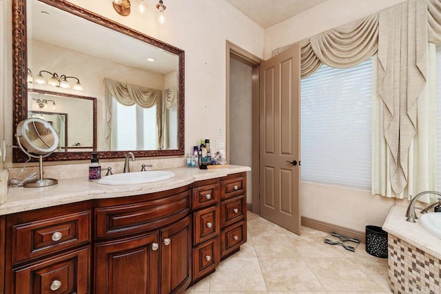 full bathroom featuring a relaxing tiled tub, vanity, baseboards, and tile patterned flooring