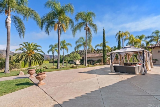 surrounding community featuring an outdoor hangout area, a gazebo, a patio area, and a mountain view