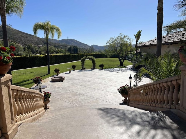 view of home's community featuring a patio, a mountain view, and a yard