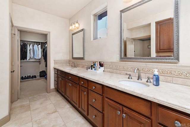 full bath featuring a sink, tile patterned floors, a spacious closet, and double vanity