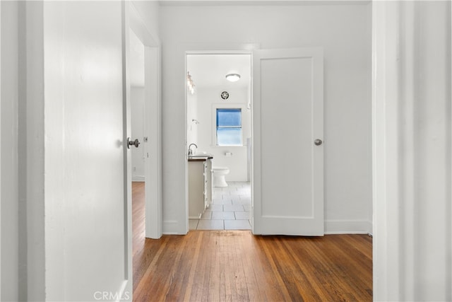 corridor with a sink and wood finished floors