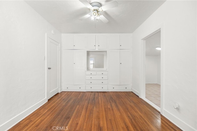 unfurnished bedroom with a closet, a ceiling fan, baseboards, and wood finished floors