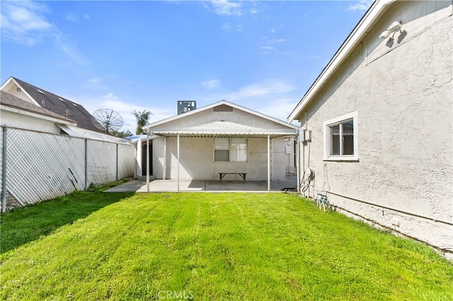 rear view of property featuring a patio, a yard, a fenced backyard, and stucco siding