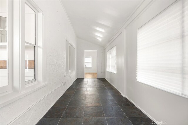 hall featuring stone finish floor and lofted ceiling