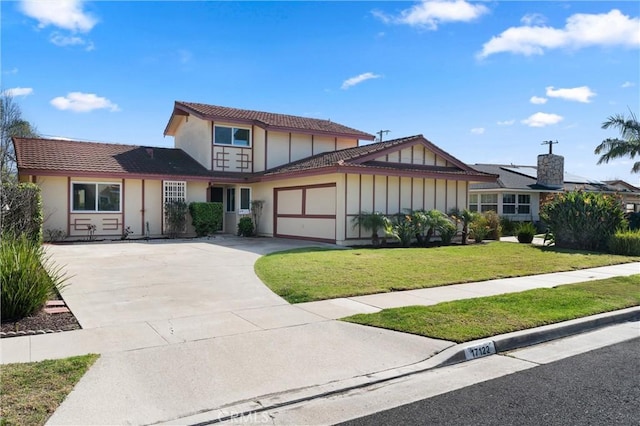 view of front of property featuring a garage, driveway, a front lawn, and stucco siding