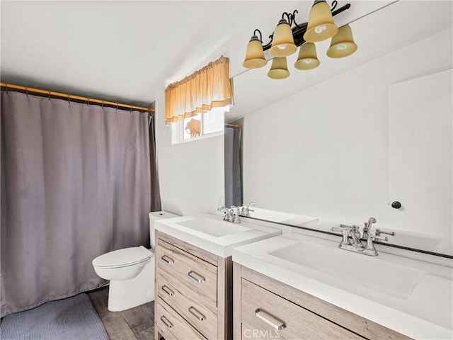bathroom featuring toilet, curtained shower, vanity, and wood finished floors