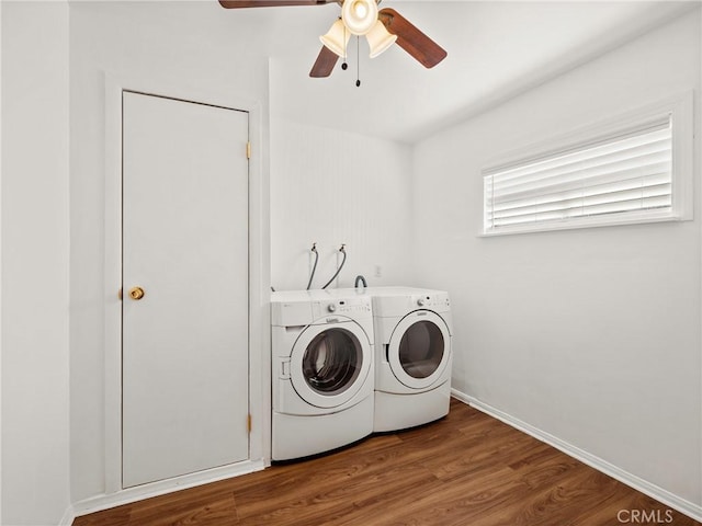 clothes washing area featuring baseboards, ceiling fan, washing machine and dryer, laundry area, and wood finished floors