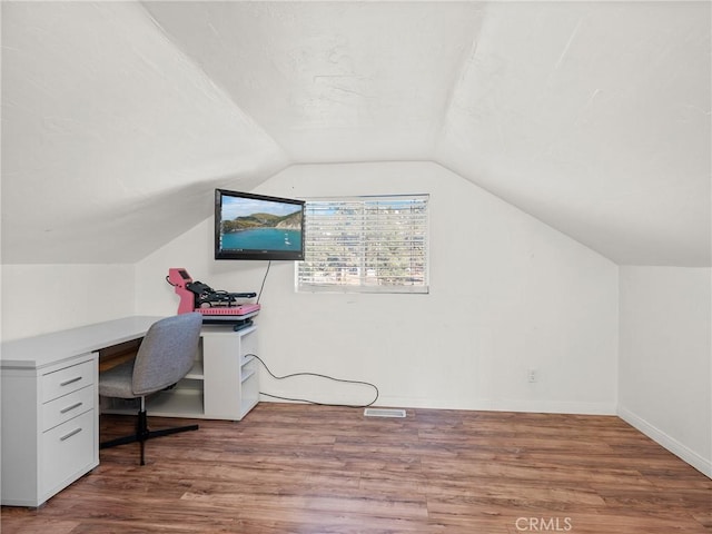 office area featuring a textured ceiling, baseboards, lofted ceiling, and wood finished floors