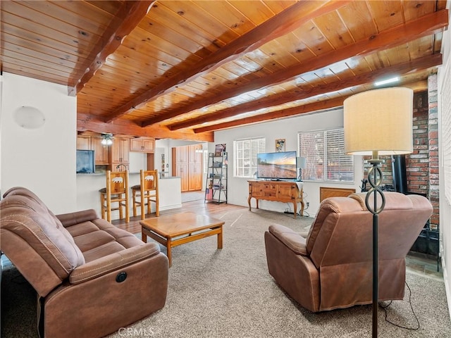 living room featuring baseboards, beam ceiling, light carpet, and wooden ceiling