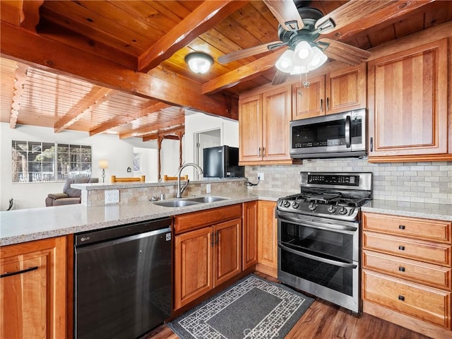 kitchen featuring a peninsula, a sink, decorative backsplash, appliances with stainless steel finishes, and wooden ceiling