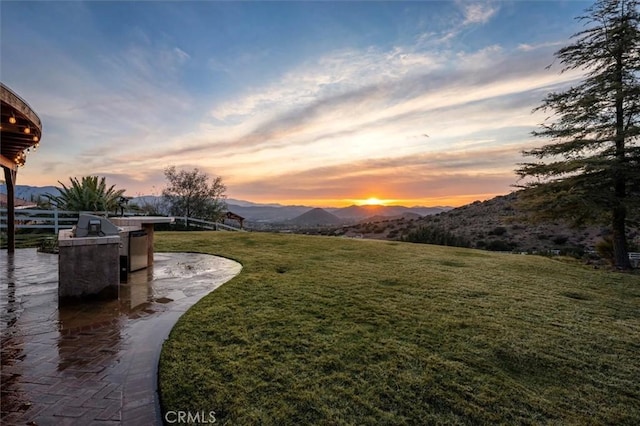 yard at dusk featuring a mountain view