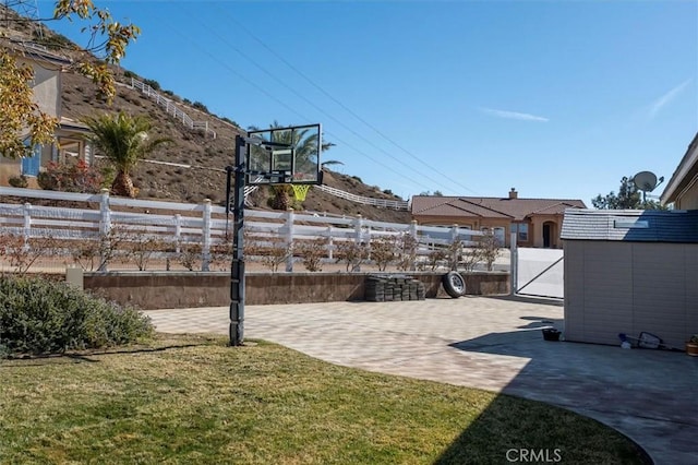 view of patio / terrace with a storage shed, an outbuilding, and fence