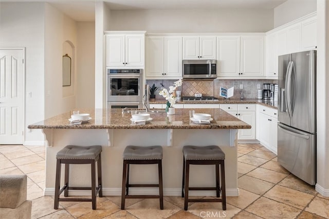 kitchen featuring an island with sink, white cabinetry, and appliances with stainless steel finishes