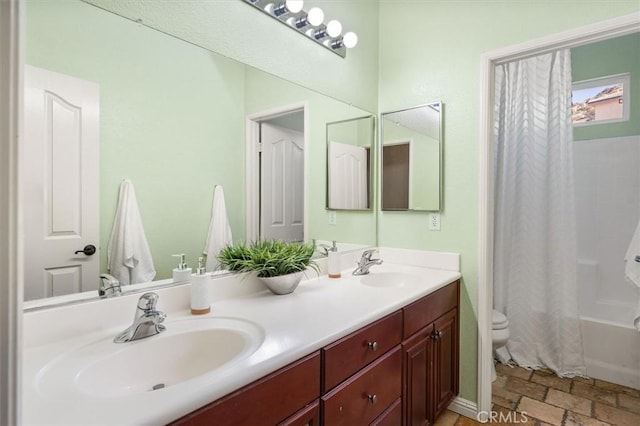 full bathroom with shower / bath combination with curtain, stone finish flooring, a sink, and double vanity