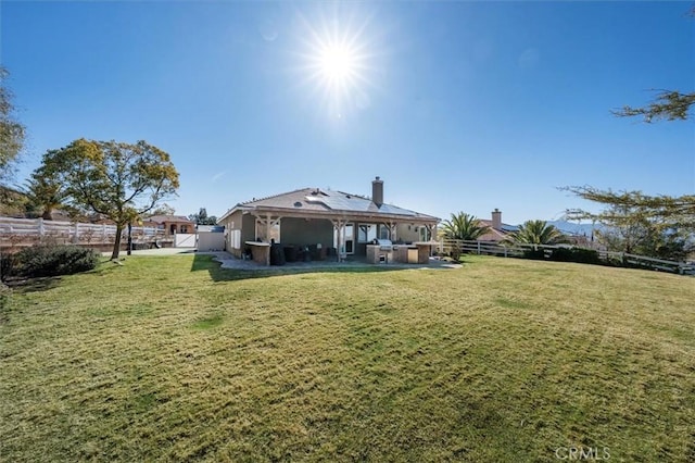 rear view of house with a fenced backyard and a lawn