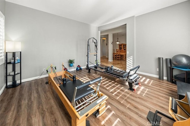 exercise room with wood finished floors and baseboards