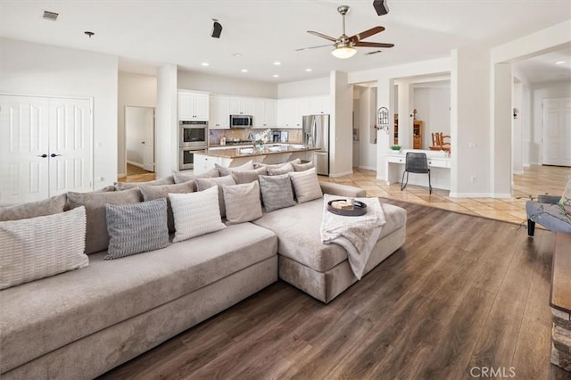 living area with recessed lighting, wood finished floors, a ceiling fan, baseboards, and visible vents