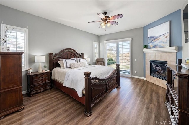 bedroom featuring access to outside, a fireplace, dark wood finished floors, and baseboards