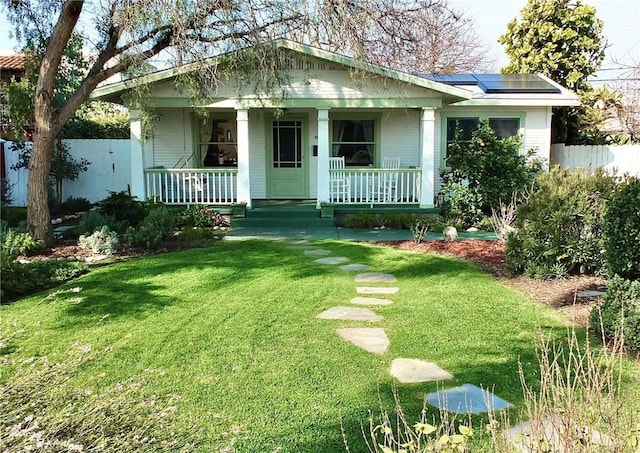 bungalow-style home with fence, a front lawn, and covered porch