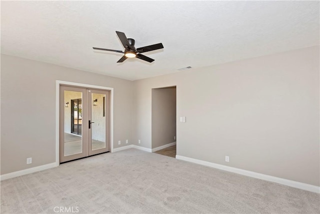 spare room featuring visible vents, baseboards, light colored carpet, and french doors