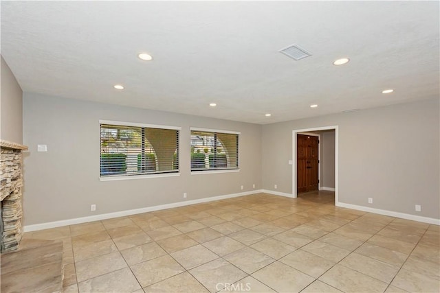 unfurnished room featuring baseboards, a fireplace, visible vents, and recessed lighting