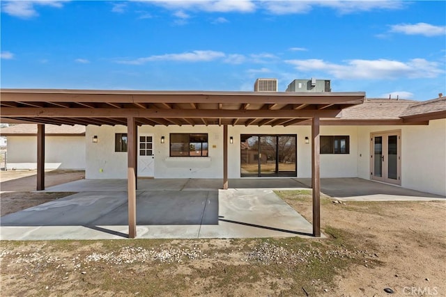 rear view of property featuring french doors, a patio, and stucco siding