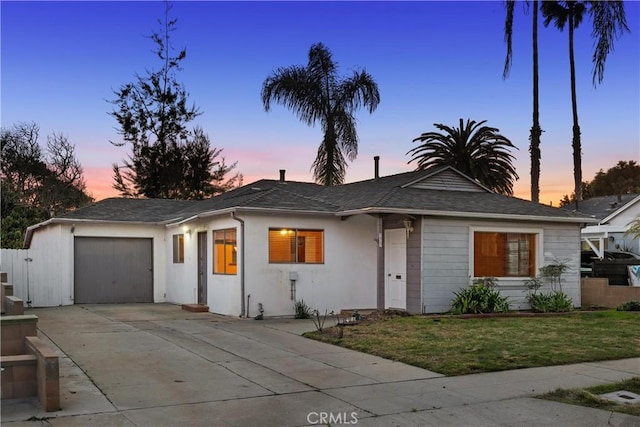 view of front of property with a garage, concrete driveway, and a yard