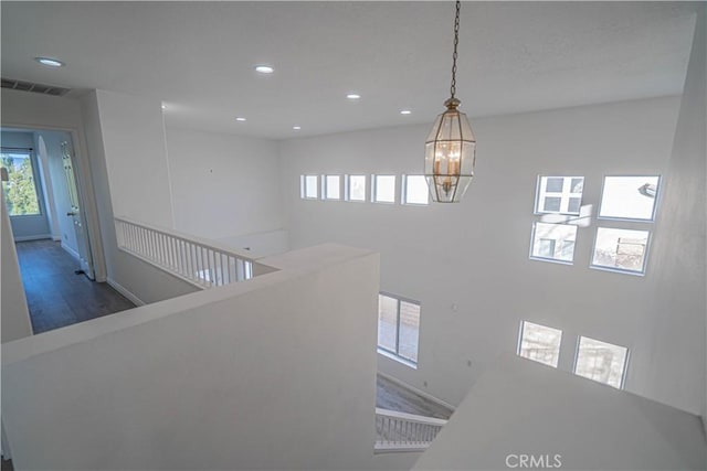 hall with visible vents, a chandelier, dark wood-type flooring, and recessed lighting