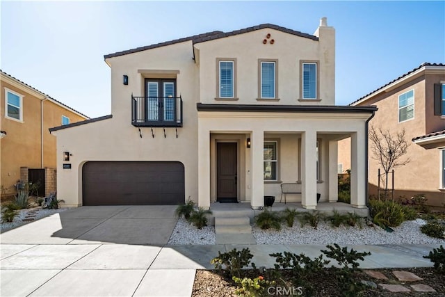 mediterranean / spanish house with covered porch, concrete driveway, and stucco siding