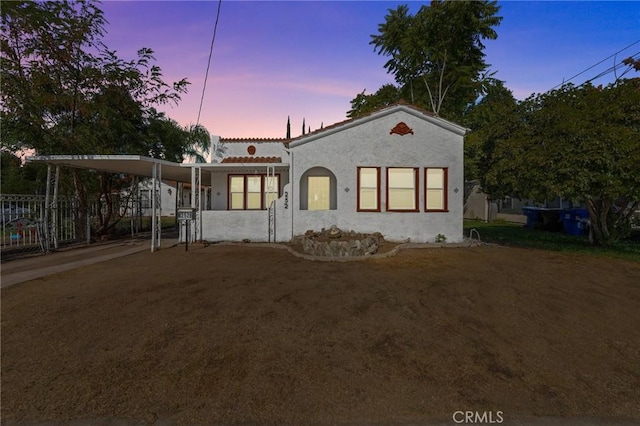 mediterranean / spanish-style house with an attached carport and stucco siding