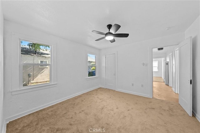 unfurnished bedroom with light carpet, a ceiling fan, baseboards, and a closet