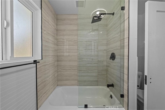 bathroom with enclosed tub / shower combo, visible vents, and toilet