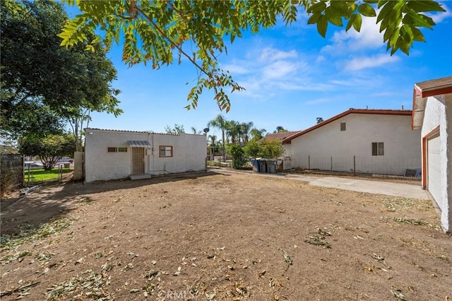 back of house featuring fence and stucco siding