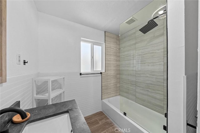 full bathroom featuring a wainscoted wall, visible vents, tile walls, vanity, and wood tiled floor