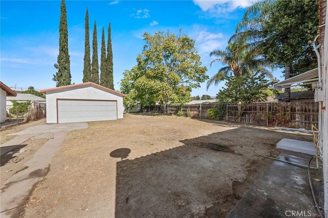 view of yard featuring an outbuilding, a detached garage, and a fenced backyard