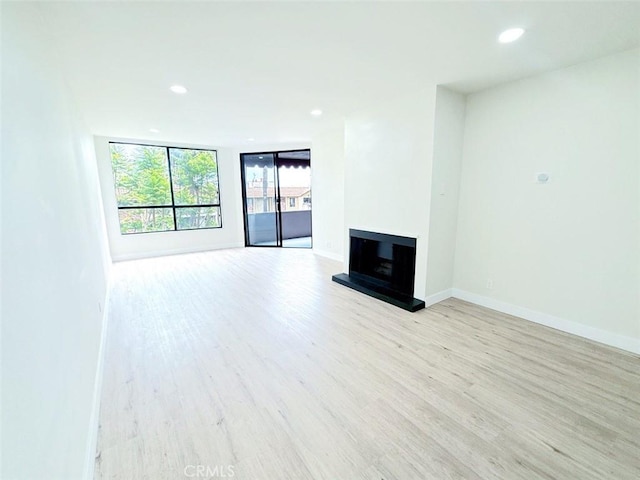 1745 Camino Palmero St Unit 537, Los Angeles, CA 90046 - unfurnished living room featuring light wood finished floors, a fireplace with raised hearth, recessed lighting, and baseboards