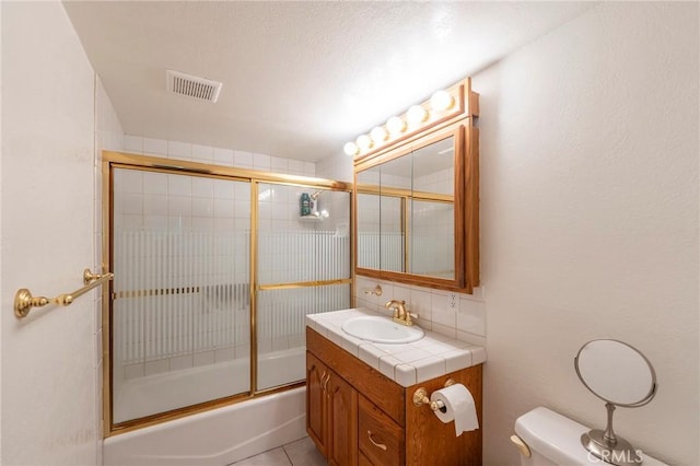 bathroom with visible vents, decorative backsplash, toilet, combined bath / shower with glass door, and vanity