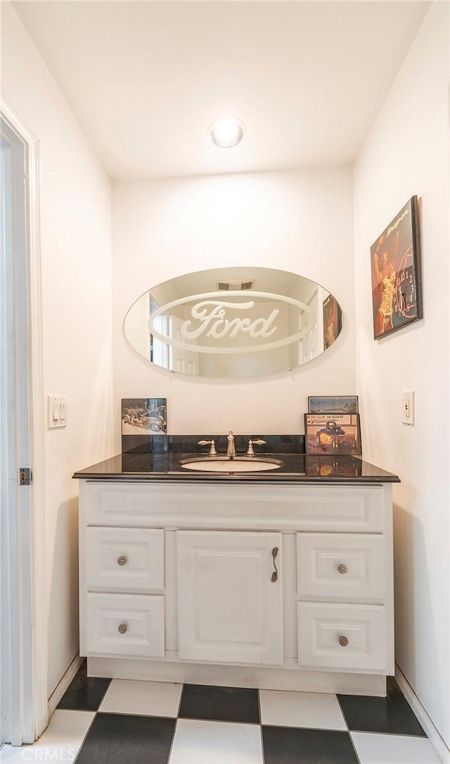 bathroom with vanity, baseboards, and tile patterned floors