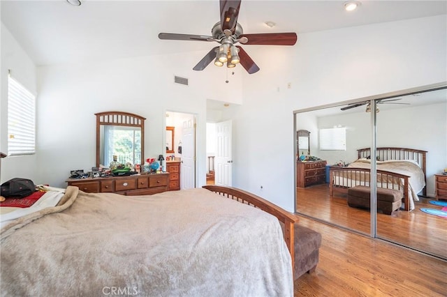 bedroom featuring ceiling fan, high vaulted ceiling, light wood-style flooring, and visible vents