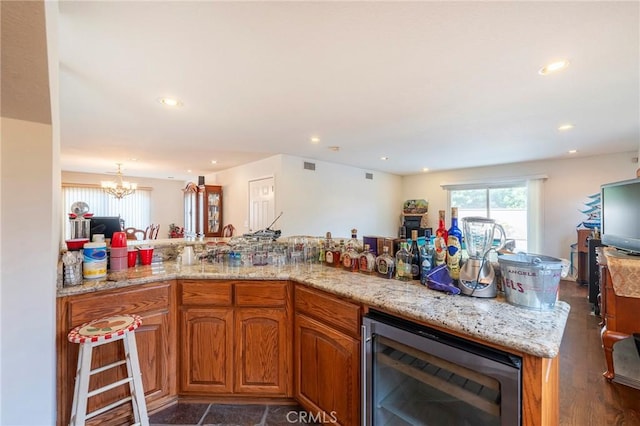 kitchen featuring wine cooler, a notable chandelier, recessed lighting, open floor plan, and brown cabinets