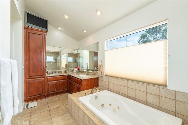 bathroom featuring tile patterned flooring, visible vents, vanity, vaulted ceiling, and a jetted tub