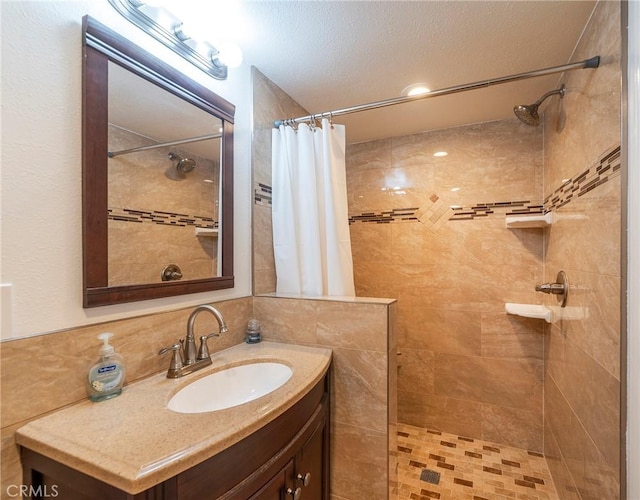 full bath featuring a tile shower and vanity